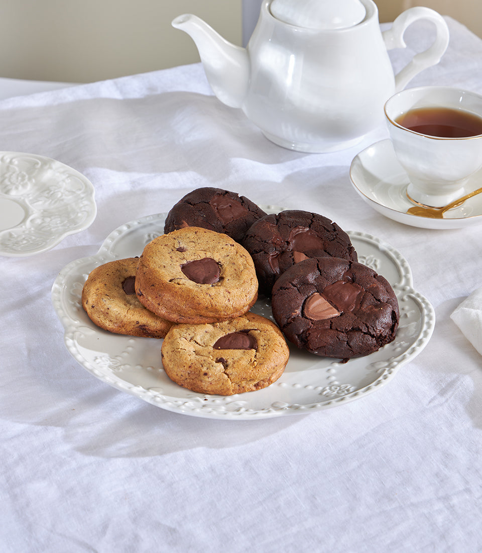 Classic chocolate chip and double choco cookies with tea service on white linen