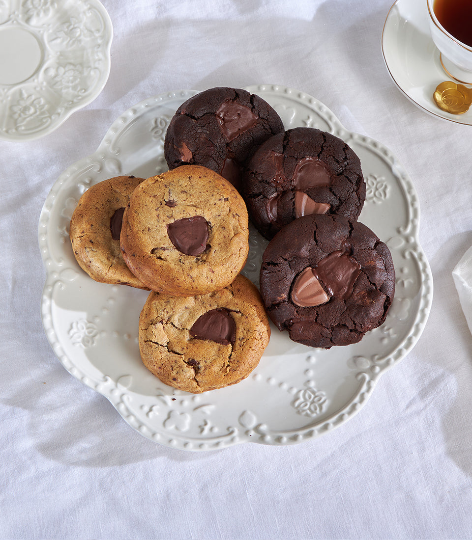 Classic and double chocolate chip cookies with melted centers on decorative ceramic plate