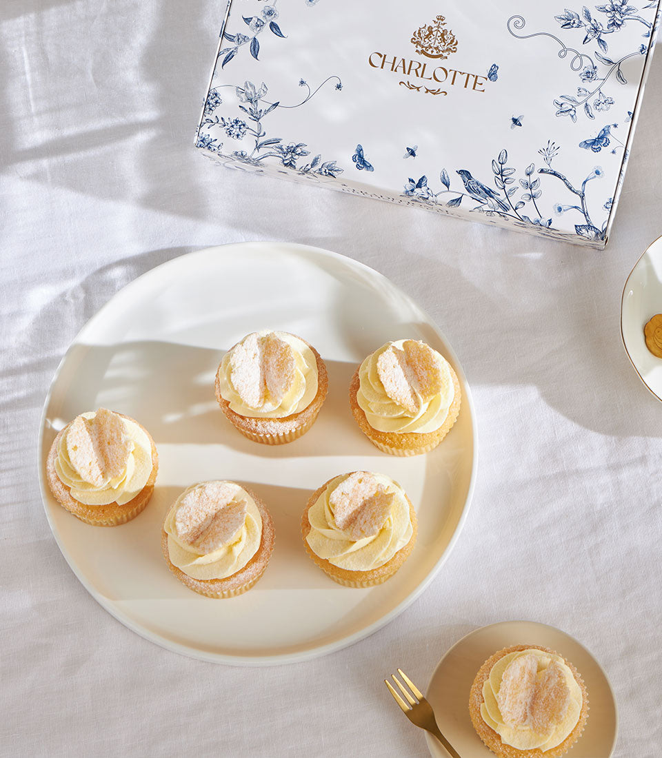 Frosted Angel Cakes with pale yellow swirl and butterfly decorations, Charlotte Bakery cupcakes for celebrations