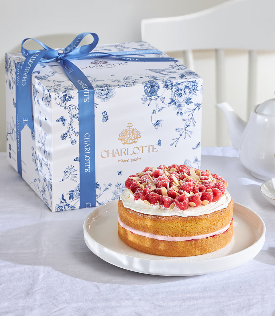 Raspberry almond celebration cake with fresh berries and slivered almonds, Charlotte Bakery signature gift box with blue