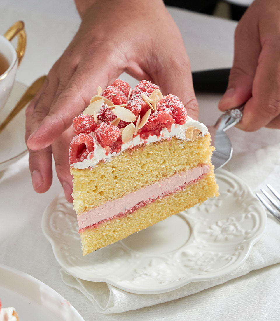 Raspberry and almond celebration cake with whipped cream and fresh berries, Charlotte Bakery signature layer cake