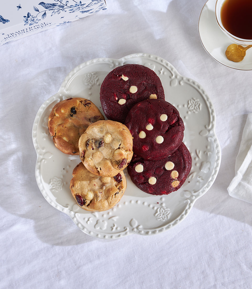 Red velvet and white chocolate macadamia cookies on scalloped plate, elegant tea time gift set