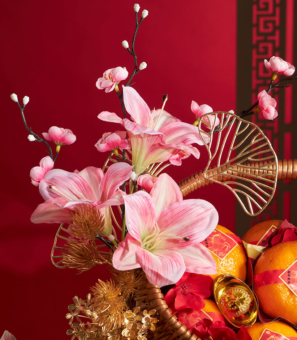 Premium Chinese New Year mandarin orange basket with fresh pink lilies, golden accents, and traditional prosperity symbols