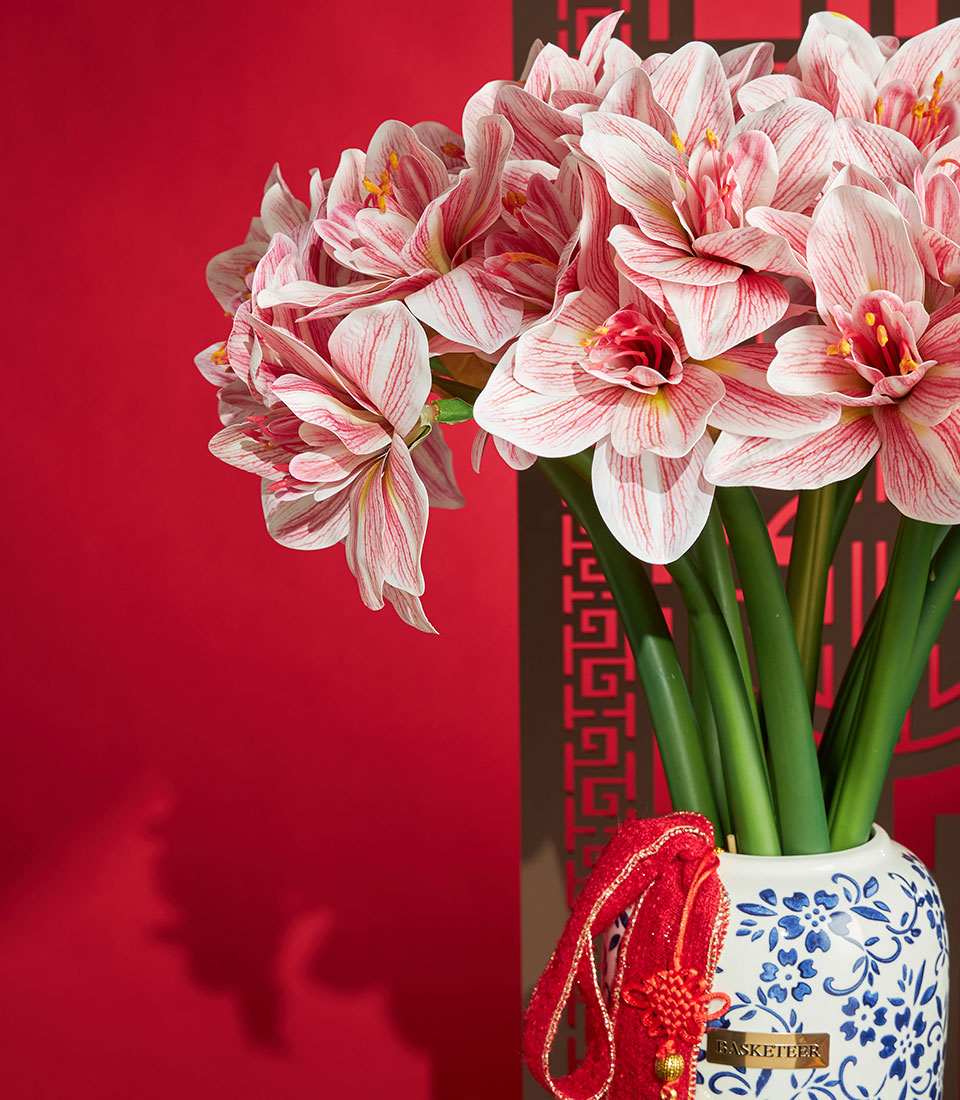 Basketeer Chinese New Year gift: Striking artificial amaryllis in a blue and white vase, plus festive red tassel. Premium hamper delivery Thailand.