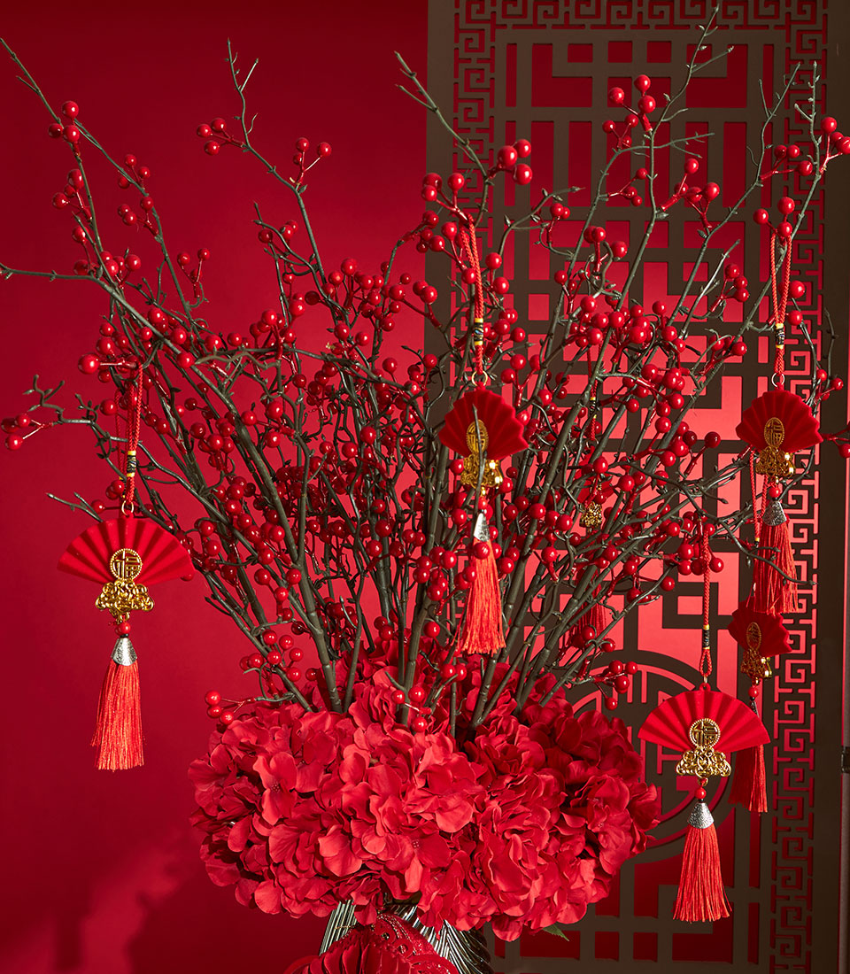 Red berry and hydrangea Chinese New Year floral arrangement with gold-accented fan ornaments