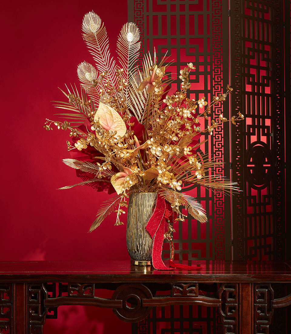 Basketeer premium hamper delivery Thailand: gold floral arrangement with feathers and red ribbon. A luxurious corporate gift for Chinese New Year.