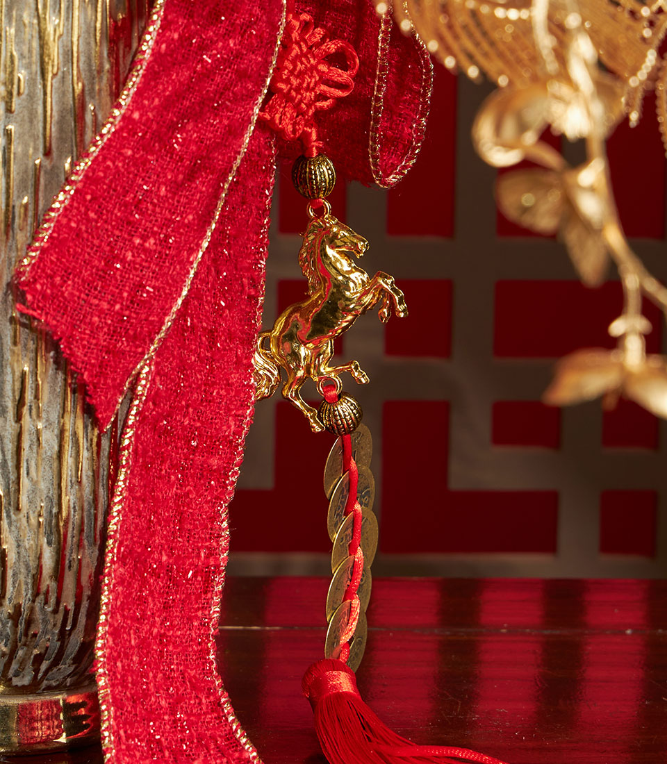 Close-up of a Basketeer luxury gift: Gold horse charm, red Chinese knot, and coins accent a floral arrangement. Perfect corporate gift for Chinese New Year in Bangkok.