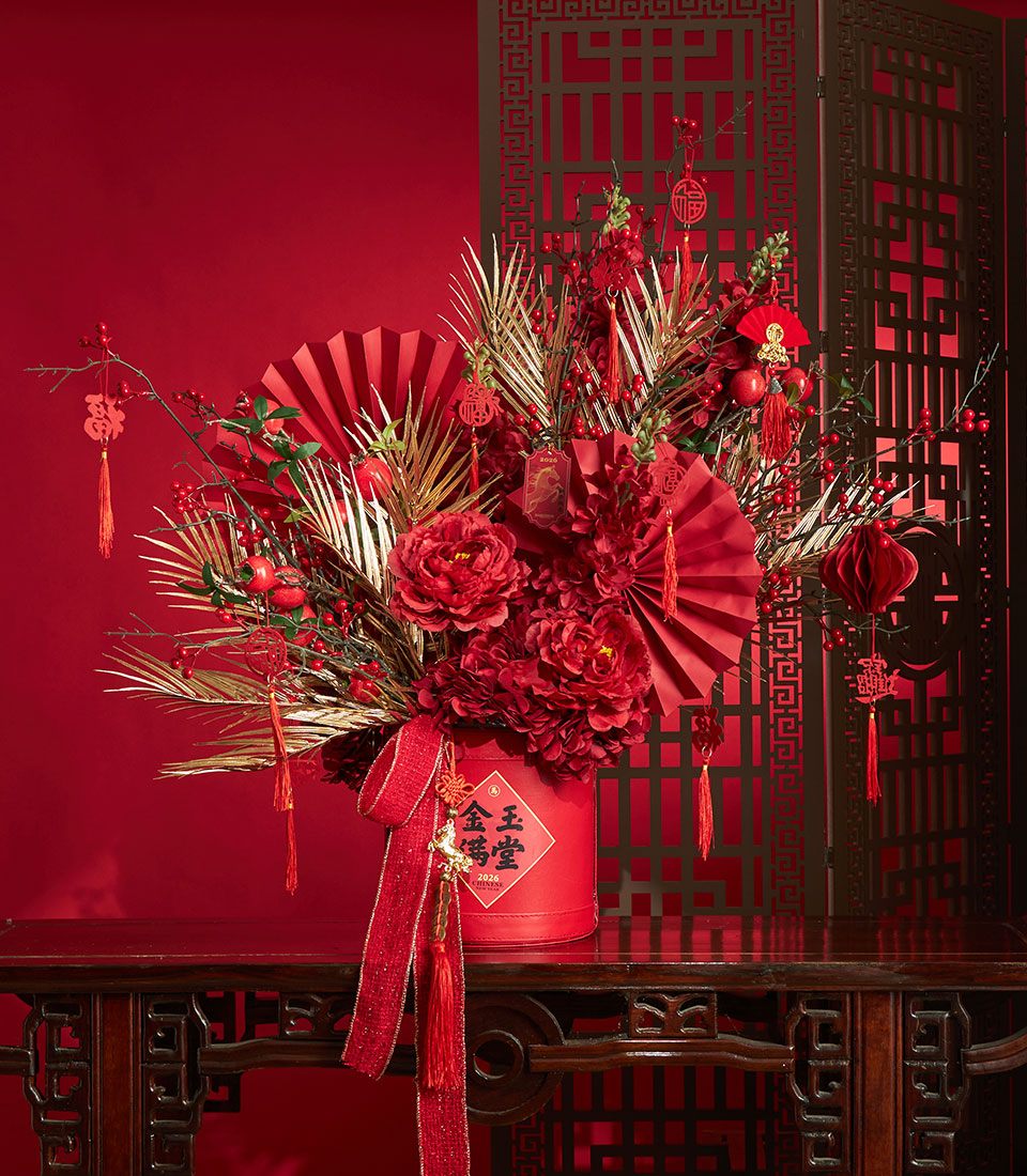 Basketeer premium hamper delivery Thailand: Red and gold floral arrangement with peonies, decorative fans, and festive hanging ornaments. Elegant corporate gift Bangkok.
