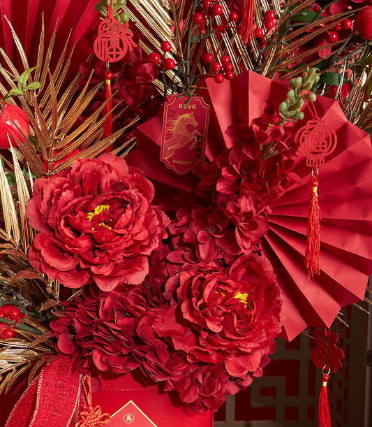 A Basketeer luxury gift arrangement for Chinese New Year. Red and gold accents, decorative fans, and lush floral blooms create a premium hamper. Perfect corporate gift for Bangkok delivery.