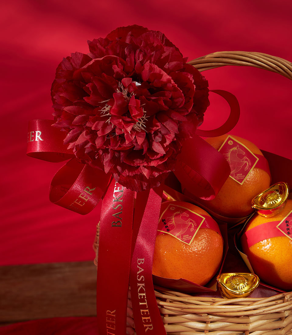 Premium wicker basket with mandarin oranges, gold accents, and deep red peony for Chinese New Year gifting