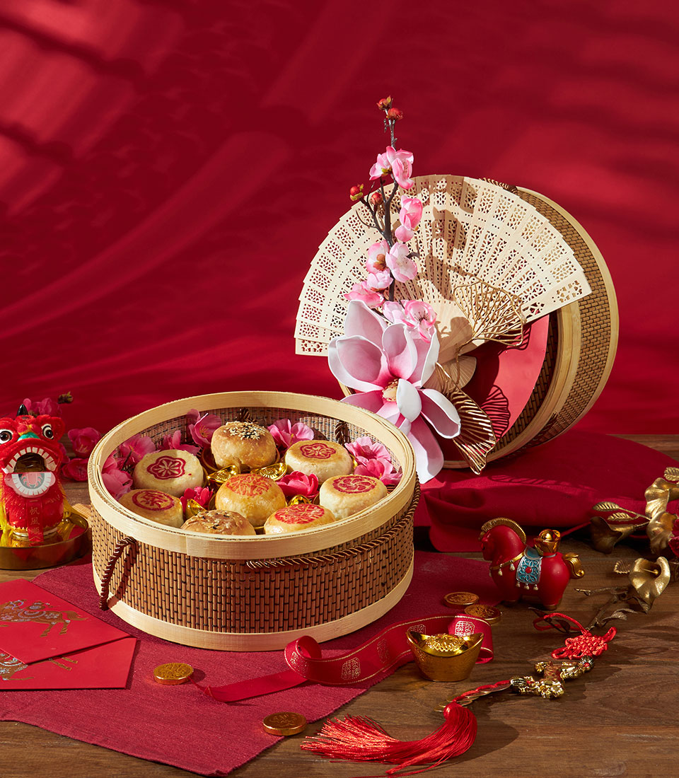 Chinese pastry gift hamper with bamboo steamers, pink florals and red accents for Lunar New Year
