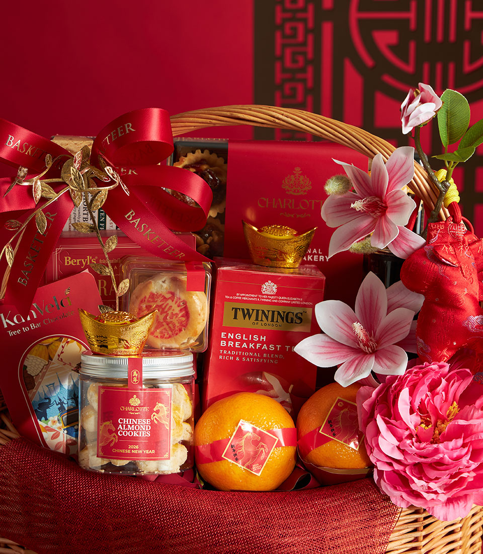 Red and gold Chinese New Year gift basket with mandarin oranges, almond cookies, English breakfast tea, and festive treats