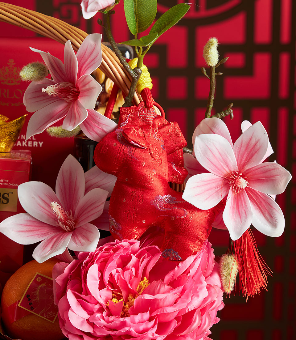 Festive red gift basket with mandarin oranges, artisan snacks, and lucky horse ornament for Chinese New Year