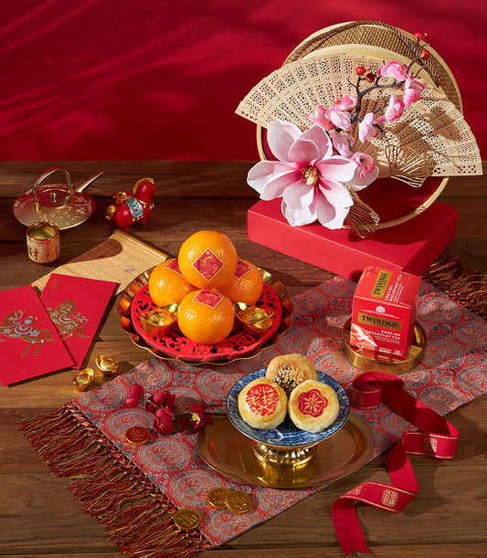 Mandarin oranges gift set with gold ingots, ceramic pastries, English breakfast tea, and festive red envelopes for Chinese