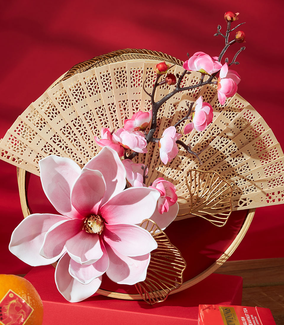 Carved wooden fan with pink magnolia and cherry blossoms on red velvet base, Chinese New Year gift hamper with mandarin
