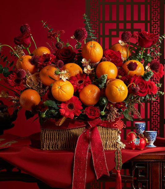 Vibrant mandarin orange and red rose floral basket with luxury gift wrapping for Chinese New Year celebrations