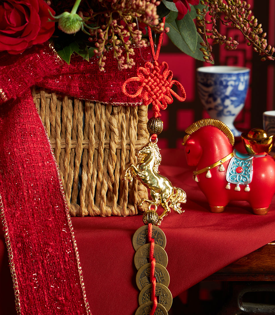 Mandarin oranges gift basket with red ribbon, Chinese knot charm, golden horse figurine, and antique coins for Chinese New