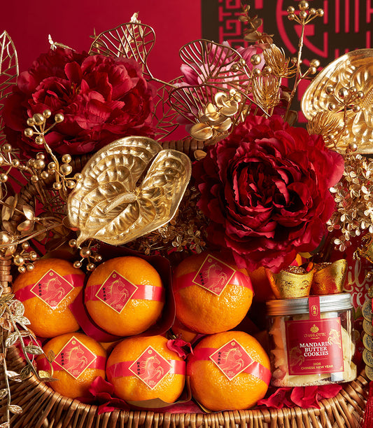 Festive Chinese New Year gift basket with mandarin oranges, mandarin butter cookies, and gold accents surrounded by red