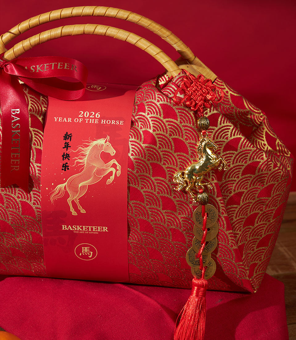 Red fabric gift basket with gold wave pattern, mandarin oranges, and lucky horse charm for Chinese New Year 2026