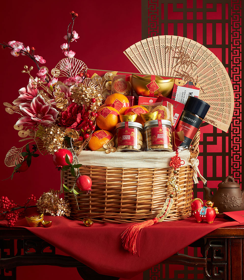 Luxury Chinese New Year gift hamper with mandarins, almond cookies, coffee, and festive gold accents in woven basket