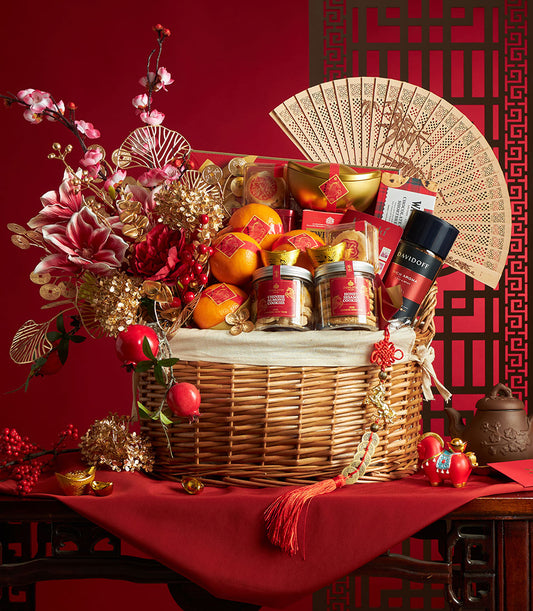 Luxury Chinese New Year gift hamper with mandarins, almond cookies, coffee, and festive gold accents in woven basket