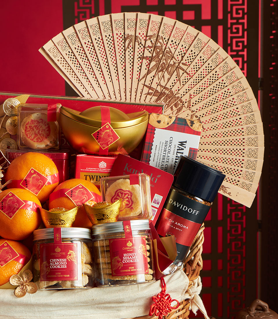 Luxury Chinese New Year gift hamper with lucky oranges, gold ingots, artisan cookies, tea, and coffee on red festive