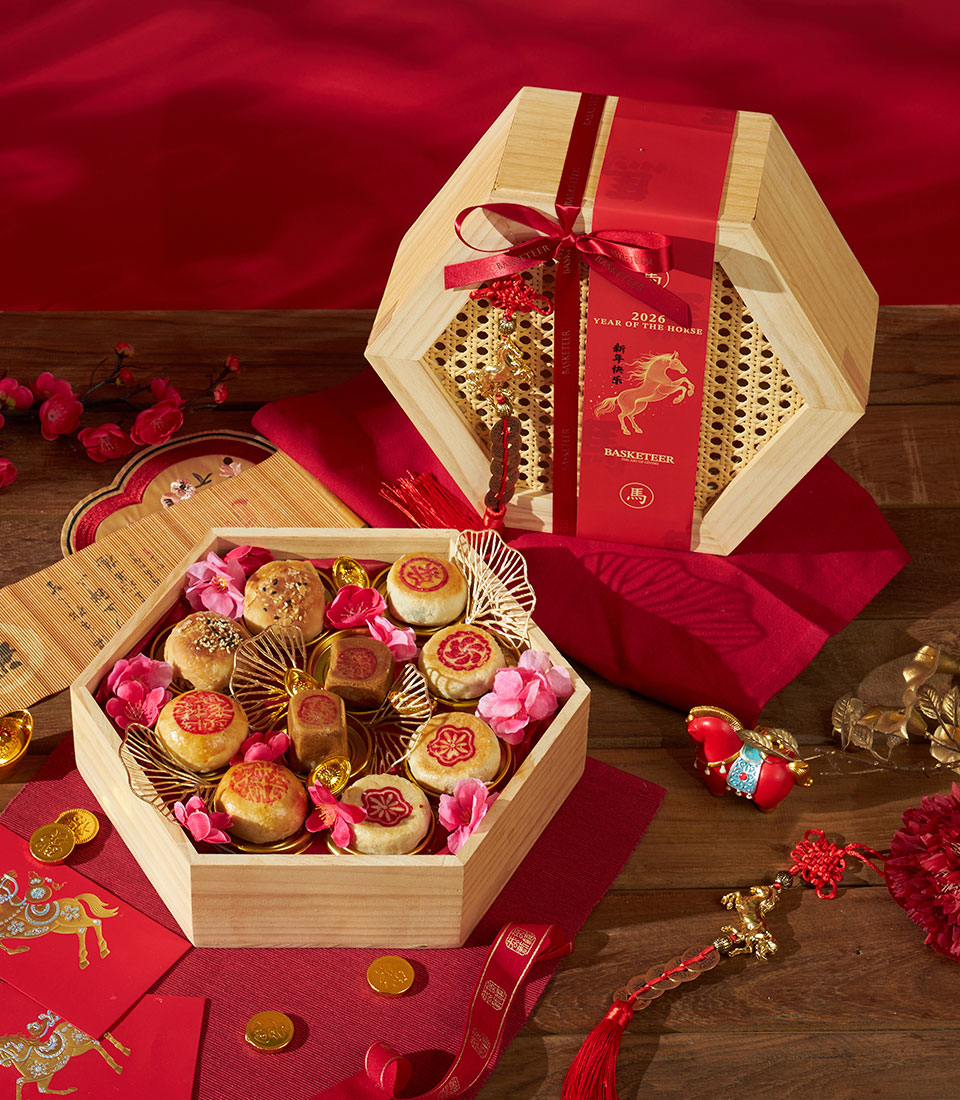 Premium Chinese New Year hexagon gift box with pastries, gold dividers, and festive red ribbon detailing