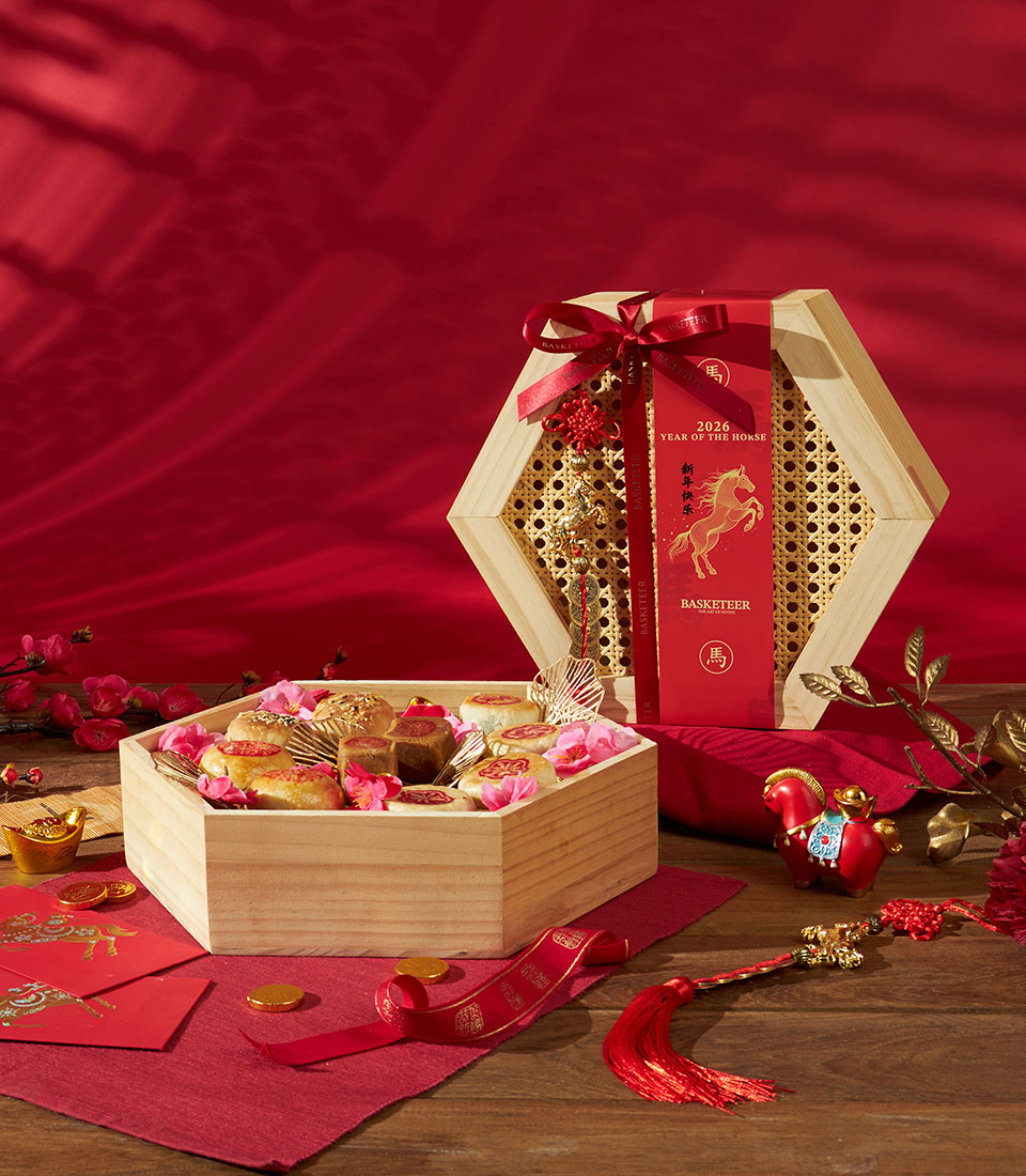 Festive Chinese New Year hexagon gift box with artisan pastries, pink petals, and gold accents in red presentation