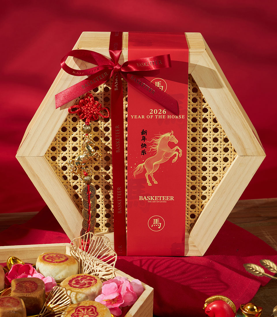Hexagonal wooden gift box with Chinese pastries, red Lunar New Year sleeve, golden horse charm, and festive red ribbon for