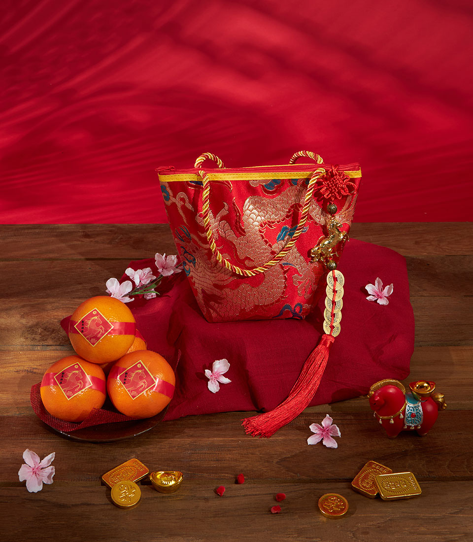 Premium red silk gift bag with gold dragon motif, mandarin oranges, and lucky charms for Chinese New Year celebrations