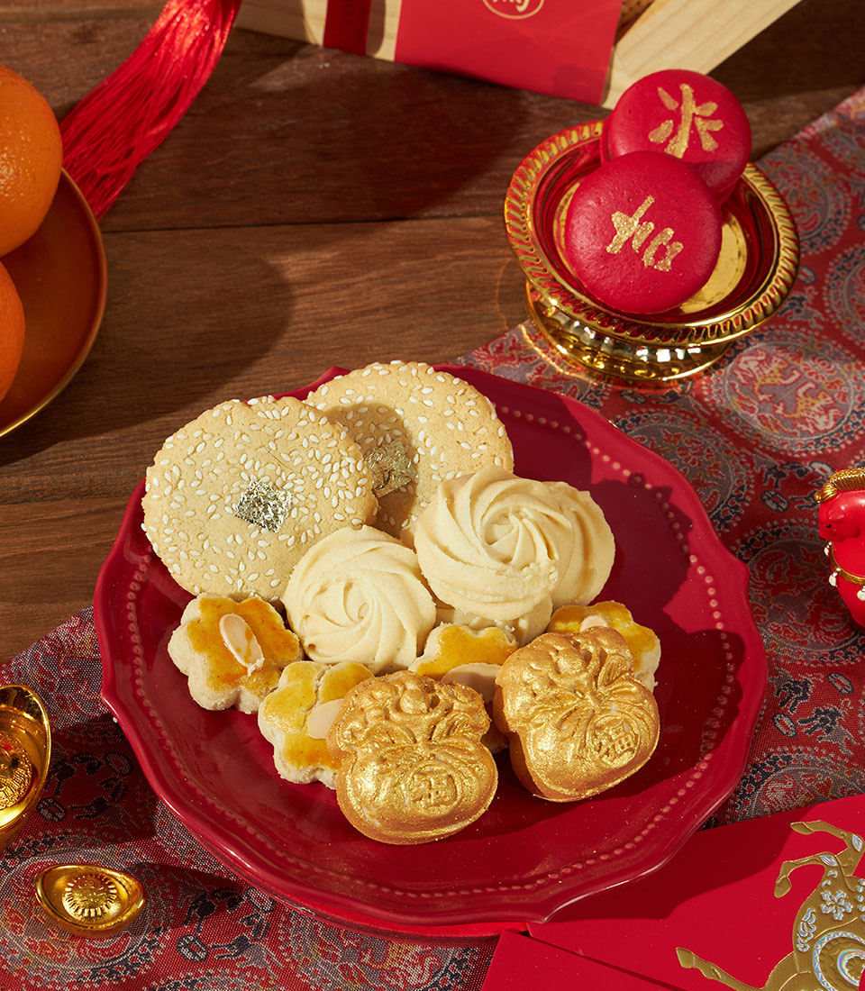 Charlotte Bakery Chinese New Year gift box with festive cookies, macarons, mandarins, and traditional red envelope