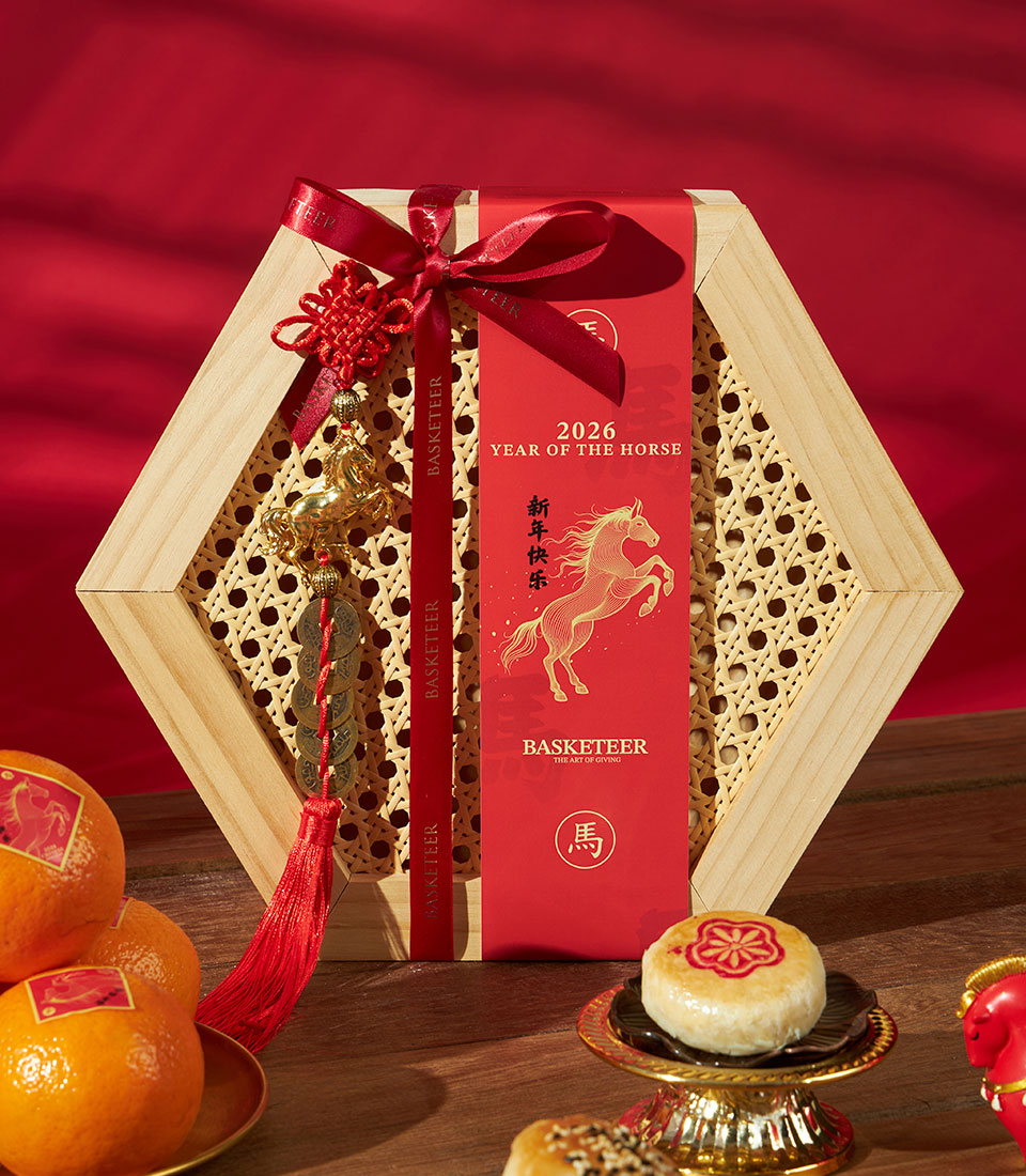 Festive Chinese New Year gift set with mandarin oranges, artisan pastries, and lucky horse charms in hexagonal rattan box