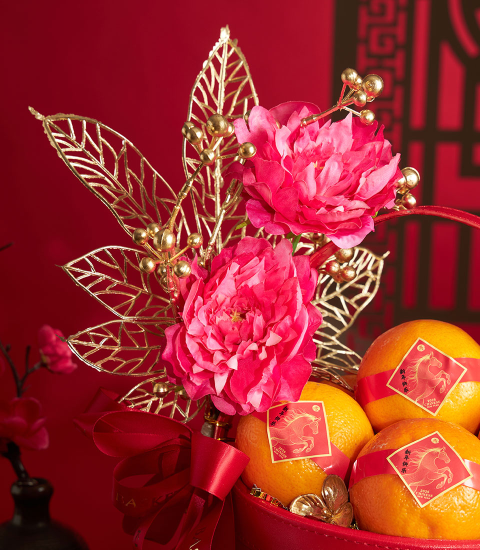 Chinese New Year mandarin orange basket with red ribbon, artificial pink peonies and gold foliage arrangement