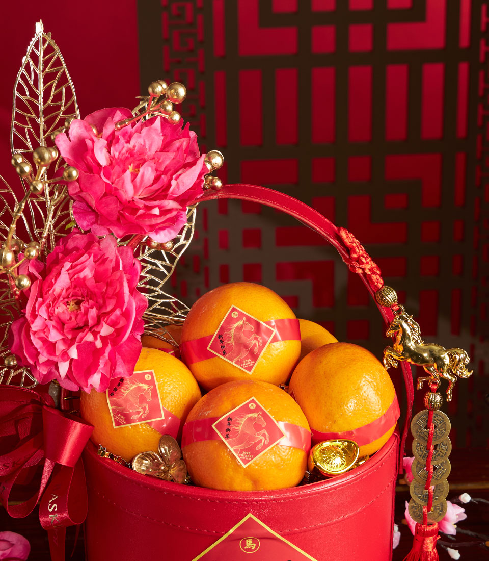 Red faux leather mandarin orange basket with pink peonies, gold metallic leaves, and Chinese New Year blessing bands