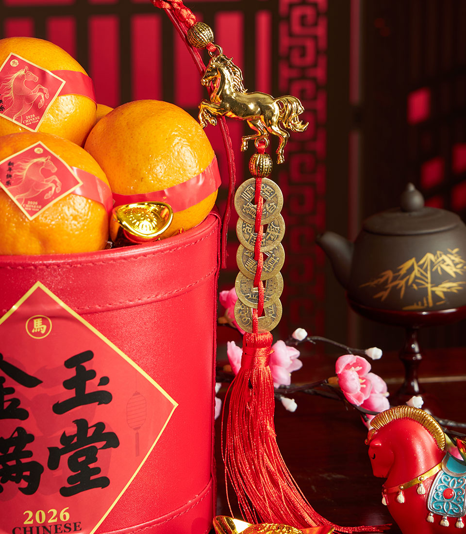 Chinese New Year mandarin orange gift basket with cherry blossom branches, golden ingots, and festive red decorative accents