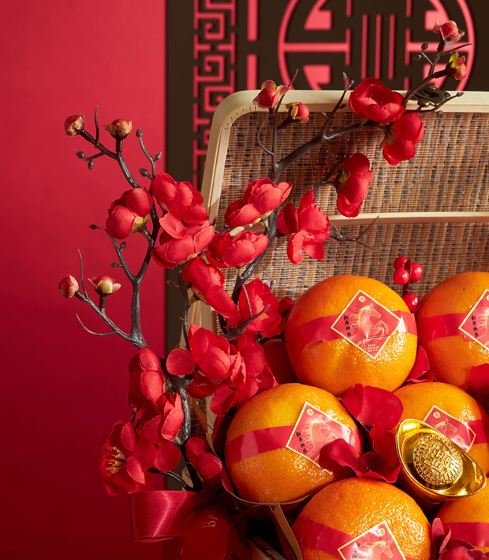Festive mandarin orange basket with red plum blossoms and golden horse stickers for Chinese New Year
