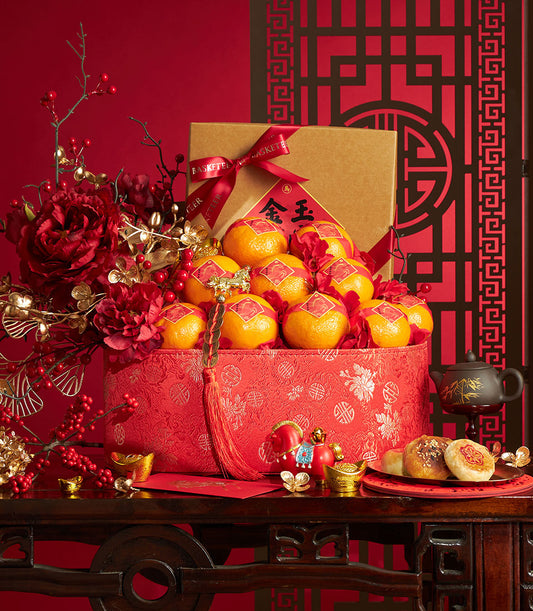 Luxury Chinese New Year gift basket with mandarin oranges, red peonies, pastries, and gold accents