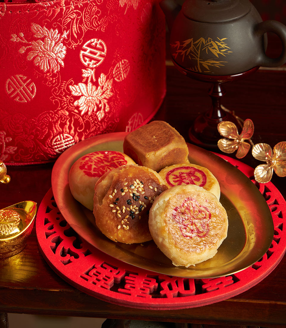 Luxury Chinese New Year gift basket with mandarin oranges, traditional pastries, and festive red ceramic teapot