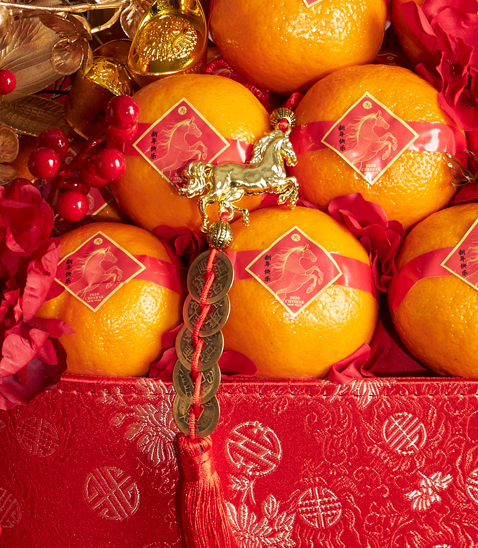 Festive Chinese New Year mandarin orange and pastry gift basket with gold horse charm and red silk ribbons