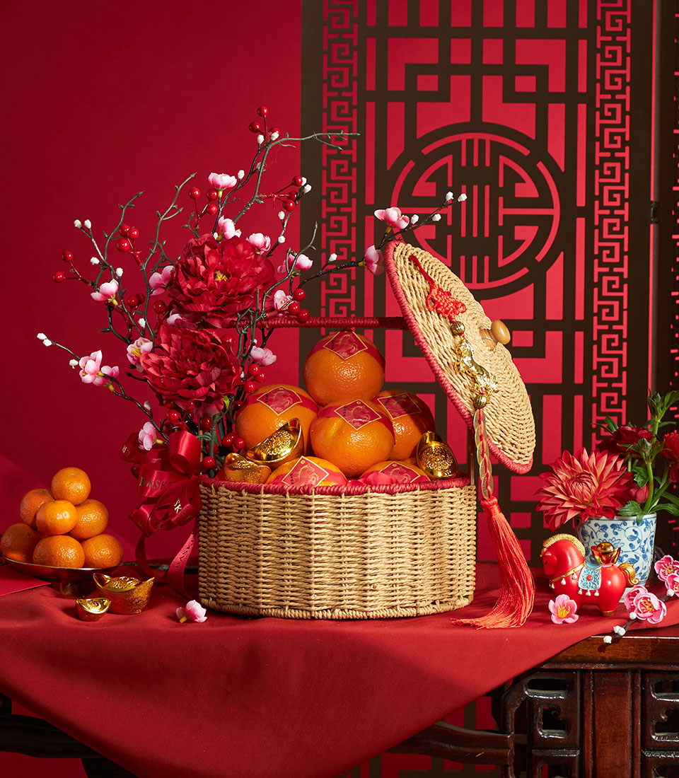 Festive Chinese New Year mandarin orange basket with red peonies, gold ingots, and lucky charms