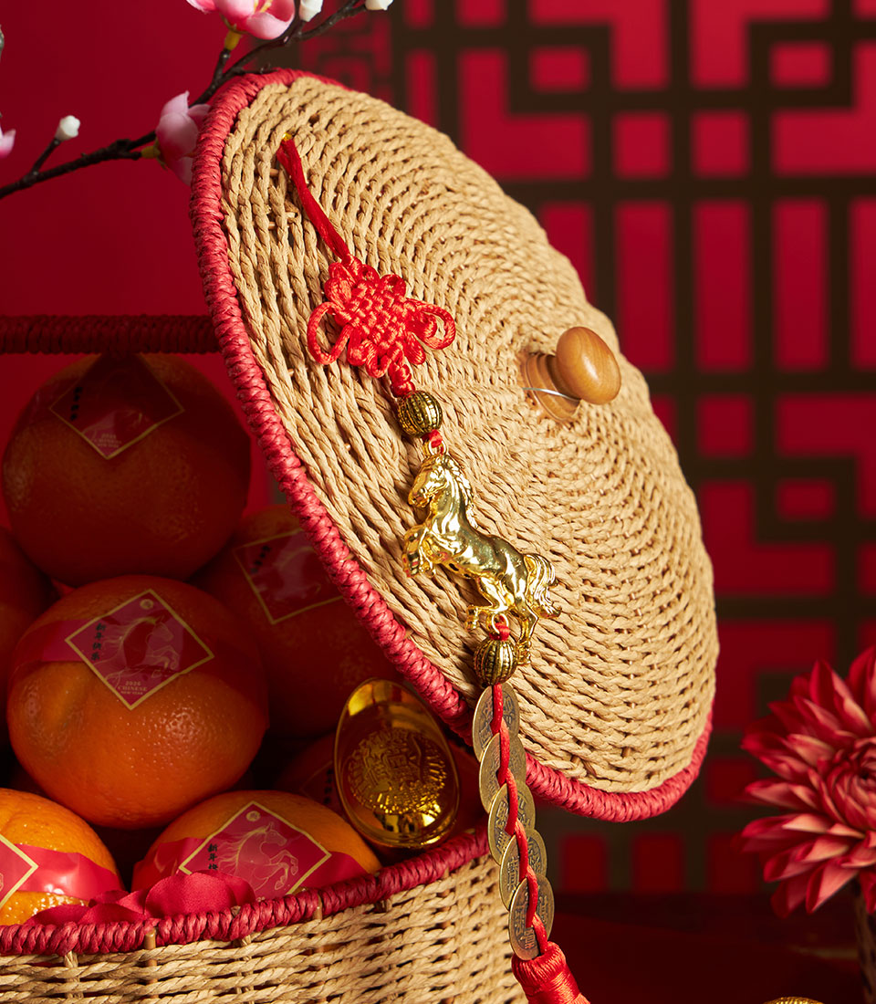 Festive Chinese New Year mandarin orange basket with red flowers, golden coins, and lucky horse charm