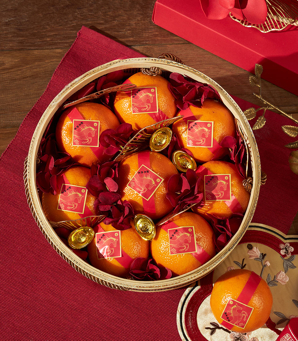 Festive mandarin oranges basket with gold horse bands for Chinese New Year, decorated with red fabric and gold sycee coins