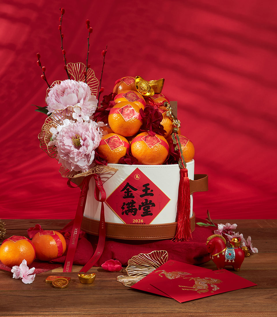 Premium Chinese New Year mandarin orange gift bucket with pink peonies, red berries, and gold accents by Basketeer