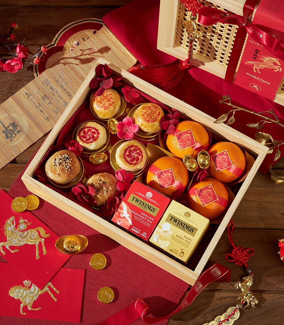 Mandarin oranges and tea luxury gift box with sesame pastries and gold coins for Chinese New Year