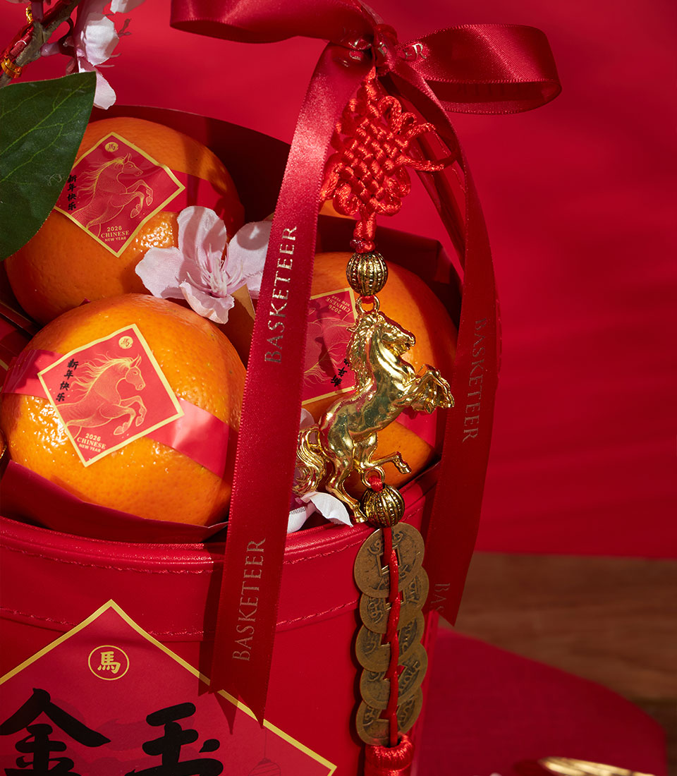 Premium mandarin oranges in red woven gift basket with golden horse charm, red ribbons, and festive Chinese New Year accents