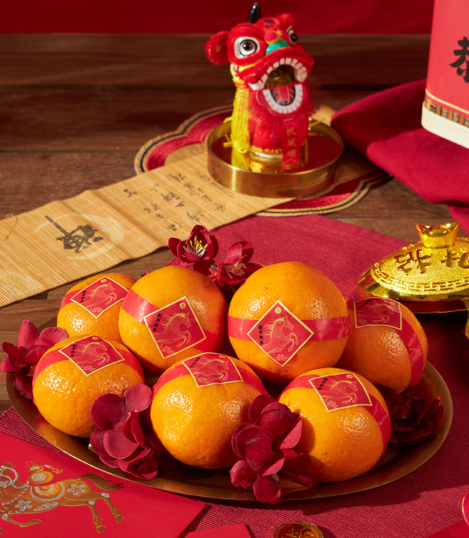 Mandarin oranges with red ribbons and Chinese festive sweets gift set for Lunar New Year celebrations