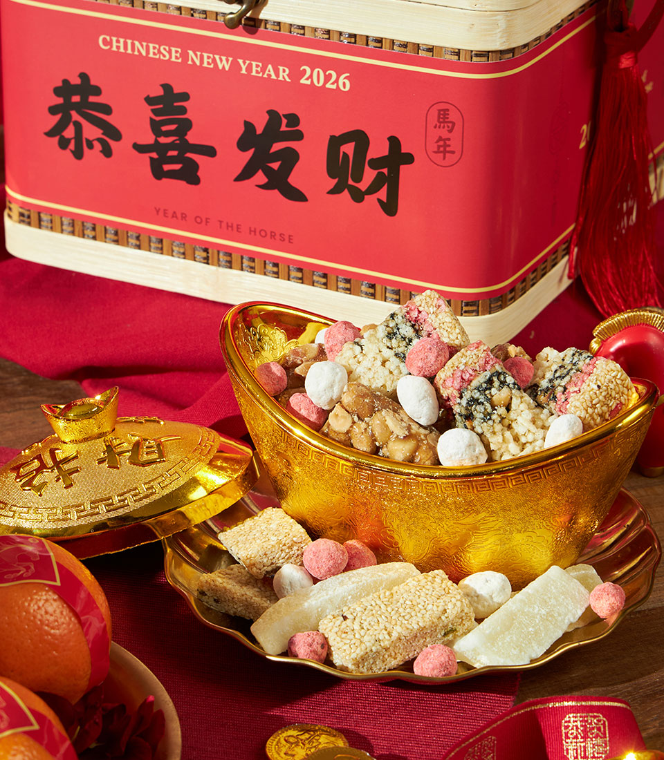 Red bamboo gift box with mandarin oranges, sesame brittle, and traditional Chinese sweets for Lunar New Year