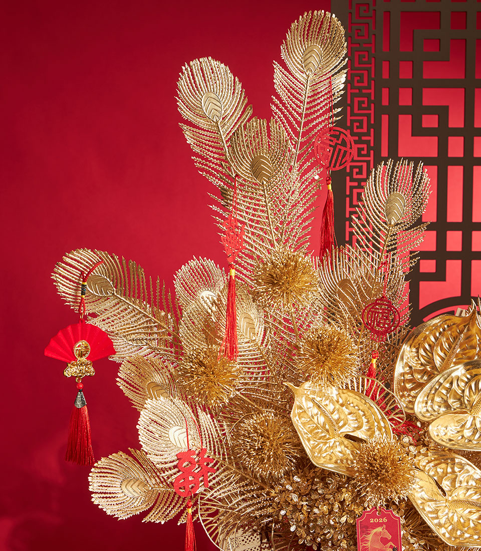 Golden peacock feathers and prosperity charms in Chinese New Year arrangement with red auspicious tassels