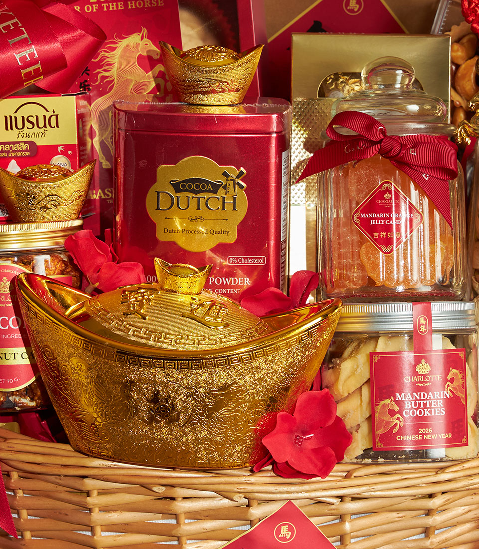 Red and gold Chinese New Year gift basket with golden ingot container, cocoa tin, mandarin candies, butter cookies, and