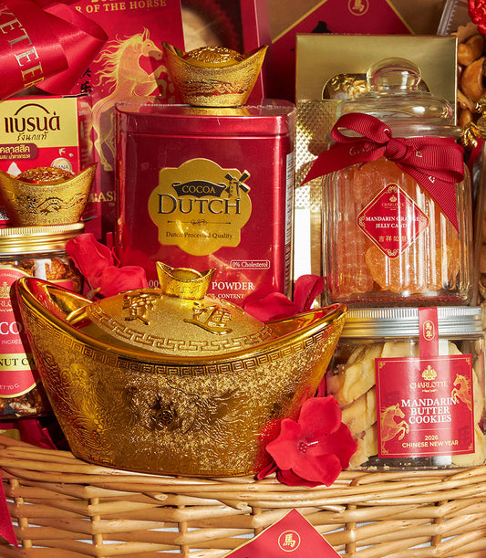Red and gold Chinese New Year gift basket with golden ingot container, cocoa tin, mandarin candies, butter cookies, and